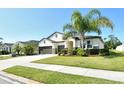 Well-maintained single-story home with a three-car garage, verdant lawn, and vibrant landscaping under a clear blue sky at 364 Grande Vista Blvd, Bradenton, FL 34212