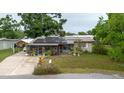 View of the front of the house with solar panels and screened porch with lush landscaping at 4015 Asbury Pl, Sarasota, FL 34233