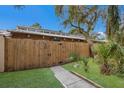 View of the backyard featuring a tall wooden fence and green grass at 500 N Jefferson Ave # G5, Sarasota, FL 34237