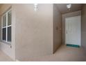 Condo entryway with a beige textured wall, Hello mat, white door, and small window at 5330 Hyland Hills Ave # 2324, Sarasota, FL 34241
