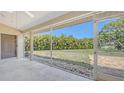Screened lanai with a serene view of the lush backyard and pond at 5698 Country Walk Ln, Sarasota, FL 34233