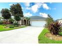 Inviting single-story home with a spacious driveway, attached garage, and verdant tropical landscaping at 5905 32Nd E St, Ellenton, FL 34222