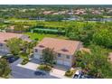 An aerial view shows the condo's location near a tennis court, a lake, and surrounded by lush greenery and well manicured lawns at 6335 Bay Cedar Ln, Bradenton, FL 34203