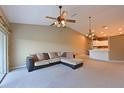 Spacious living room featuring a ceiling fan, stylish lighting, and a breakfast bar connecting to an adjacent kitchen space at 6335 Bay Cedar Ln, Bradenton, FL 34203