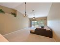 Bright living room with a ceiling fan, contemporary lighting fixtures, a loft area, and sliding door access to a balcony at 6335 Bay Cedar Ln, Bradenton, FL 34203