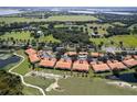 Aerial view of condos featuring tile roofs and beautiful landscaping in a desirable golf course community at 7155 Boca Grove Place Pl # 202, Lakewood Ranch, FL 34202