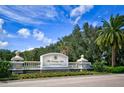 Elegant entrance to The Country Club at Lakewood Ranch, featuring a stone wall and manicured landscaping at 7155 Boca Grove Place Pl # 202, Lakewood Ranch, FL 34202