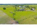 Expansive green property featuring a home, outbuildings, and fenced perimeters at 7745 Wauchula Rd, Myakka City, FL 34251
