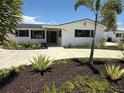 Inviting front exterior with a well-maintained lawn and tropical plants at 808 25Th W Ave, Palmetto, FL 34221