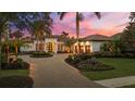 Elegant Mediterranean-style home featuring a circular driveway, lush landscaping, and a grand entrance at 8312 Catamaran Cir, Lakewood Ranch, FL 34202