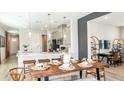 Elegant dining area with a modern table setting adjacent to the kitchen and living space at 8632 Snowfall St, Sarasota, FL 34241