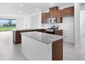 Kitchen with granite countertops, stainless steel appliances, a kitchen island and stainless steel dishwasher at 8632 Snowfall St, Sarasota, FL 34241