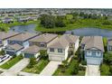 Aerial view of a home with a pond in the background, surrounded by lush trees and other homes in the community at 9148 Royal River Cir, Parrish, FL 34219