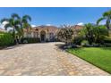 Stunning home featuring a red tile roof, manicured landscaping and a brick paver driveway on a sunny day at 9719 Discovery Ter, Bradenton, FL 34212