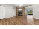 Bright living room featuring a stone fireplace, wood-look floors and sliding glass doors to the back at 1035 Axlewood Cir, Brandon, FL 33511