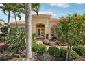 Inviting front entrance with double doors and a beautifully landscaped garden at 1251 Tuscany Blvd, Venice, FL 34292