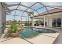 Enclosed pool area showcasing a sparkling pool with rock features and scenic lake views at 1251 Tuscany Blvd, Venice, FL 34292