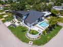Aerial view of stunning modern home with a pool, manicured lawn, and beautiful landscaping at 1323 Loma Linda Ct, Sarasota, FL 34239