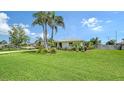 Single-story home with well-manicured lawn, tropical landscaping, and charming curb appeal at 1334 De Prie Rd, Englewood, FL 34223