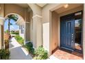 Inviting covered front porch featuring a stylish blue entry door and well-maintained landscaping at 138 Tiziano Way, North Venice, FL 34275