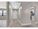 Bright hallway with wood-look flooring, white trim, and access to the kitchen, offering a glimpse of the home's layout at 1409 57Th W St # 1409, Bradenton, FL 34209
