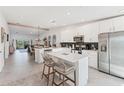 Open-concept kitchen featuring stainless steel appliances, white cabinets, and an island with seating at 14257 Heritage Landing Blvd # 1122, Punta Gorda, FL 33955