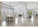 Bright and airy dining room featuring stylish light fixture, open to the living area with neutral decor at 17547 Cantarina Cv, Bradenton, FL 34211