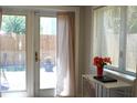 View of a backyard area through open doors next to a window and a table with flower decor at 204 36Th W St, Bradenton, FL 34205