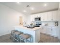 Bright kitchen featuring white cabinetry, stainless steel appliances, and a center island with barstool seating at 2081 Basin St, Port Charlotte, FL 33952