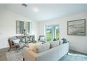 Open living room area with contemporary decor, neutral tones, and sliding glass doors to the backyard at 23440 Avacado Ave, Punta Gorda, FL 33980