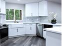 Bright kitchen featuring white cabinets, stainless appliances, a farmhouse sink and a view of the trees outside at 27944 Green Willow Run, Wesley Chapel, FL 33544
