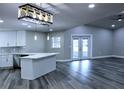 Open-concept living space boasting modern lighting, updated kitchen features and views of the backyard at 27944 Green Willow Run, Wesley Chapel, FL 33544