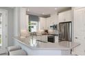 Bright kitchen featuring stainless steel appliances, white cabinetry, and a breakfast bar with seating at 3204 Torta Ct, Bradenton, FL 34211
