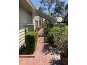 Side walkway with brick pavers, well-manicured hedges and flowering plants at 3407 Avenida Madera # A, Bradenton, FL 34210
