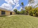 Spacious backyard features healthy green grass with a patio area and privacy fence at 3698 N Chamberlain Blvd, North Port, FL 34286