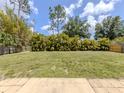 Expansive backyard featuring green grass, lush privacy hedges, and a classic wood fence at 3698 N Chamberlain Blvd, North Port, FL 34286