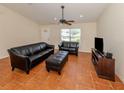 Cozy living room features tiled floors and a ceiling fan above a seating area at 3698 N Chamberlain Blvd, North Port, FL 34286