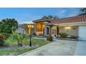 Well-lit home with a red tile roof, beautiful landscaping, and a spacious driveway at 387 Eden Dr Dr, Englewood, FL 34223