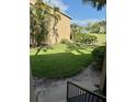 Backyard view of the condo with a green lawn and manicured shrubs, adding to the property's charm at 4037 Crockers Lake Blvd # 24, Sarasota, FL 34238