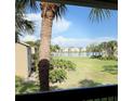 Scenic view from the balcony of a lush lawn and a serene lake, enhancing the condo's appeal at 4037 Crockers Lake Blvd # 24, Sarasota, FL 34238