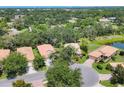 Aerial view of a neighborhood featuring well-maintained homes, mature trees, and a tranquil pond at 4121 Reflections Pkwy, Sarasota, FL 34233