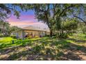 Beautiful backyard with lush greenery, mature trees, and a screened-in patio for outdoor living at 4121 Reflections Pkwy, Sarasota, FL 34233