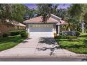 Charming single-story home with a tile roof, a two-car garage, and a well-manicured front yard at 4121 Reflections Pkwy, Sarasota, FL 34233