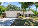 Attractive single-story home with a well-maintained lawn, palm trees, and attached two-car garage at 4253 Prairie View Dr, Sarasota, FL 34232