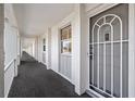 An exterior shot of a condo unit featuring a doorway and a long, well-lit hallway with railings at 4310 Falmouth Dr # 307, Longboat Key, FL 34228