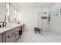 Modern bathroom featuring a glass shower, dual sinks and sleek, gray cabinets at 4696 Del Sol Blvd, Sarasota, FL 34243