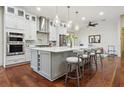 Modern kitchen with gray island, white cabinets, stainless steel appliances, and pendant lighting at 4696 Del Sol Blvd, Sarasota, FL 34243