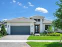 Well-maintained single-story home featuring a manicured lawn, tidy landscaping, and a gray two-car garage at 4988 Fairhope Cir, Lakewood Ranch, FL 34211
