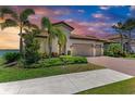 Beautiful single-Gathering home with a two car garage and brick paver driveway at sunset at 501 Maraviya Blvd, Nokomis, FL 34275