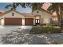 Charming single-story home with a well-manicured lawn and a three-car garage, set under a beautiful blue sky at 5240 Silver Charm Ter, Wesley Chapel, FL 33544